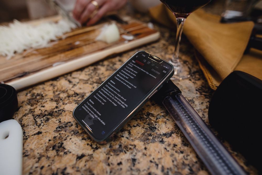 Close-up view of a woodworker using rulers and measuring tools on a granite countertop in a workshop.
