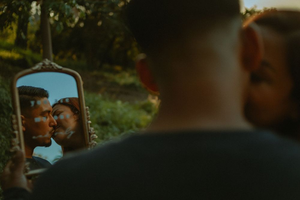 Engagement photography with couple kissing in a mirror reflection