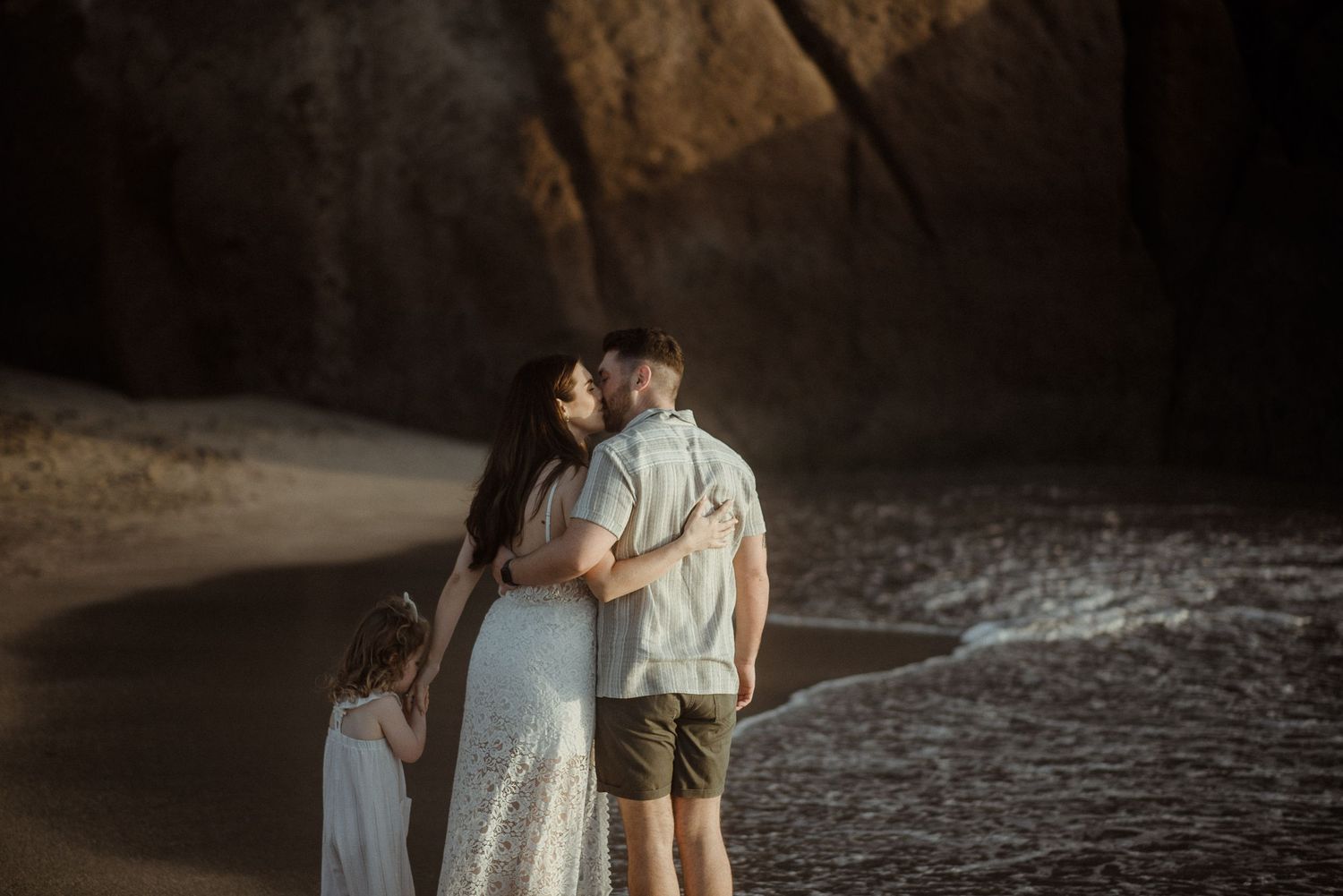 Couple embraces on beach near rocky cliffs during sunset. Tenerife Wedding Photographer at Playa del Duque, Adeje.