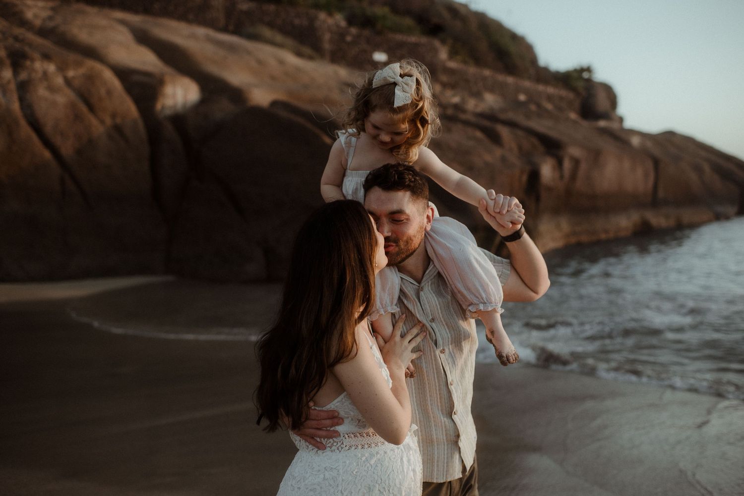 A family shares joyful moments together on a rocky beach. Tenerife Wedding Photographer at Playa del Duque, Adeje.