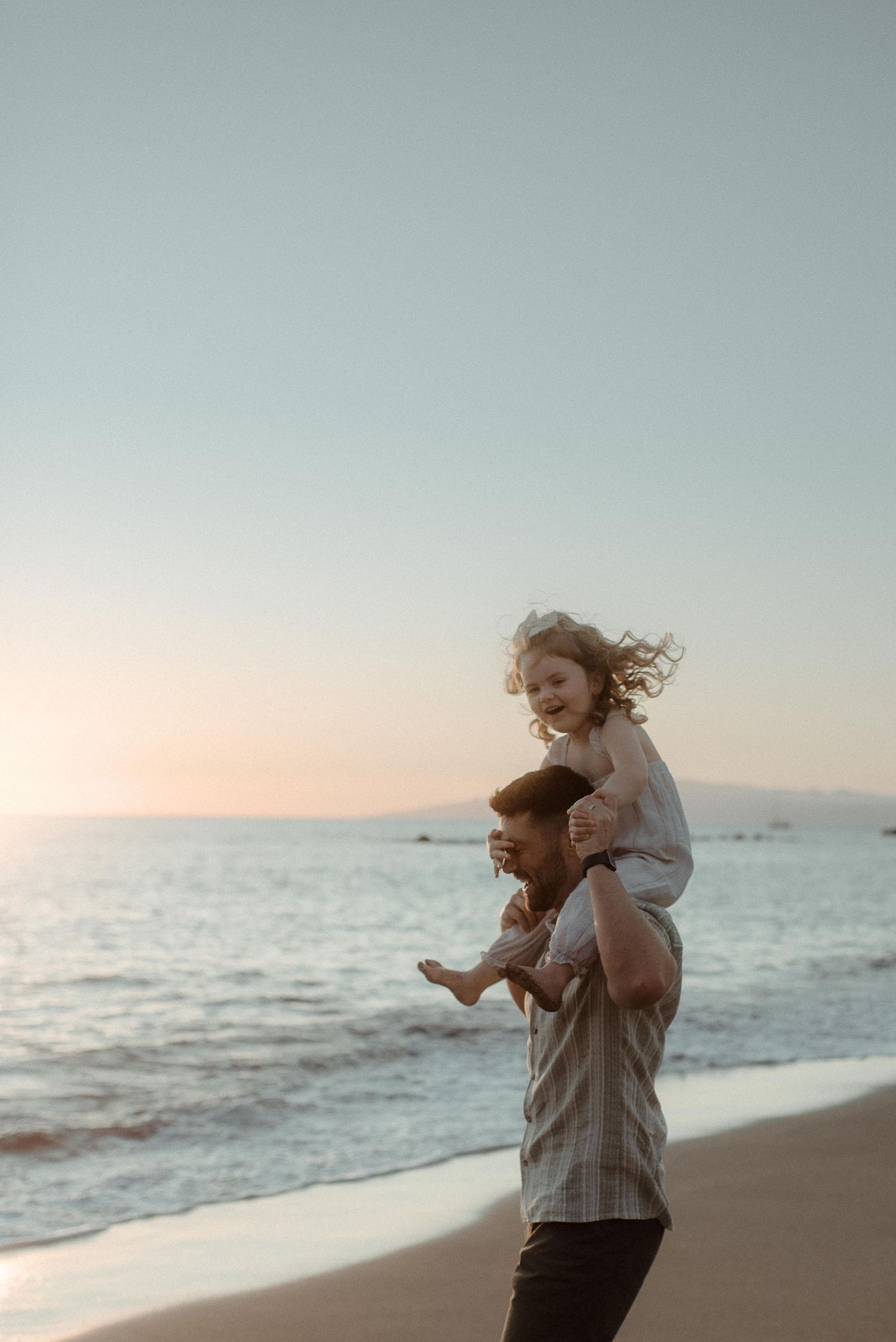 A playful moment shared between family members on a sunset beach. Tenerife Wedding Photographer at Playa del Duque, Adeje.