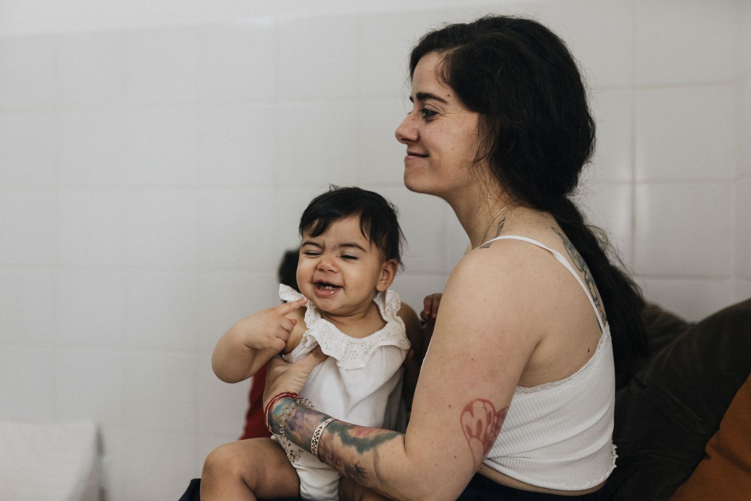 Parent and child share a joyful candid moment together while sitting indoors.