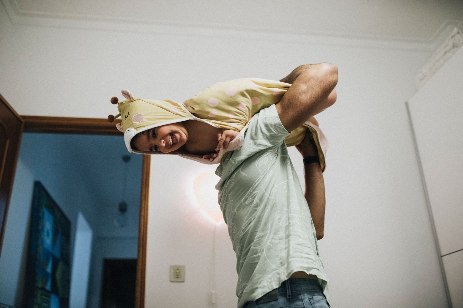 A person stretches and bends backwards in an indoor room showing flexibility against a white wall.