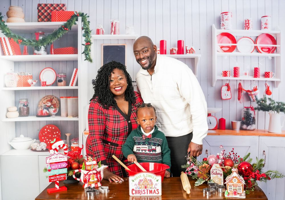 Festive holiday decor scene featuring red and white plaid patterns, garland and rustic Christmas themed accessories against white walls.