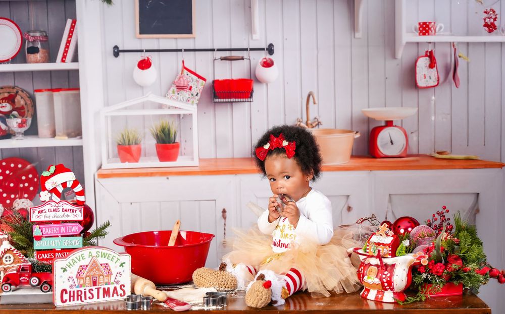 Red and white Christmas decorations arranged in a rustic scene with holiday ornaments and festive vignettes.