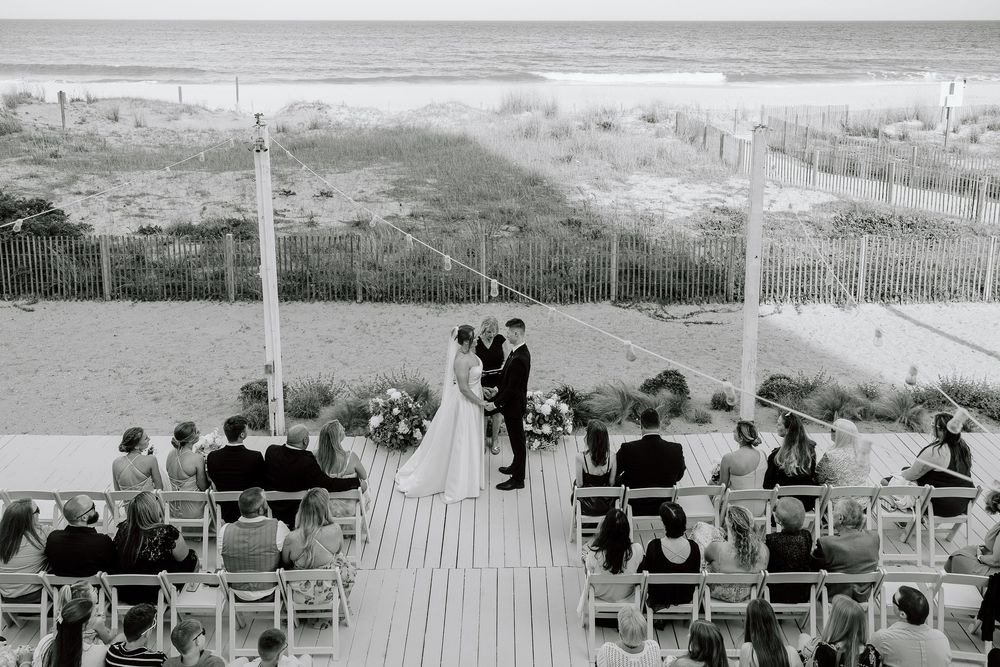 A black and white photograph shows spectators watching a sporting event from a grandstand at a stadium.