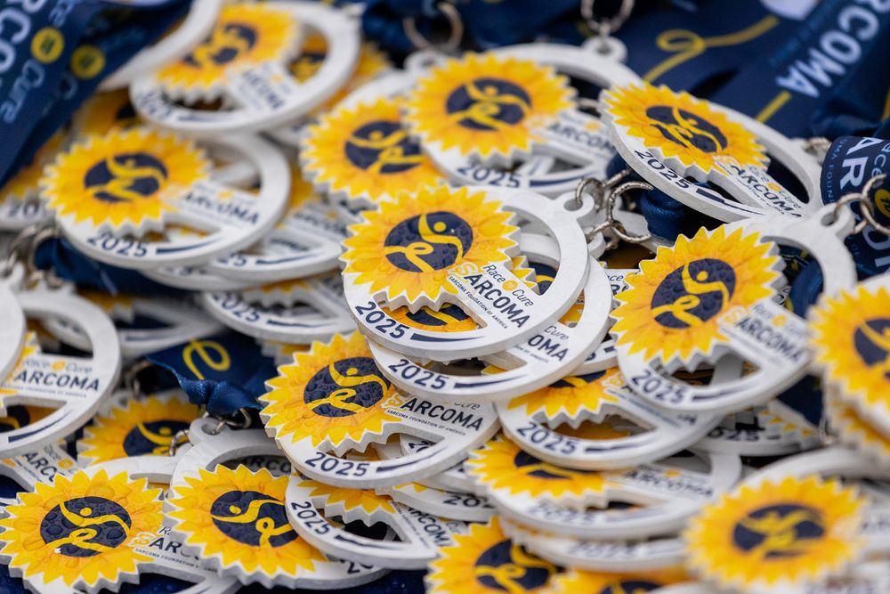 A close-up view of multiple circular yellow and silver buttons or pins arranged in overlapping rows.