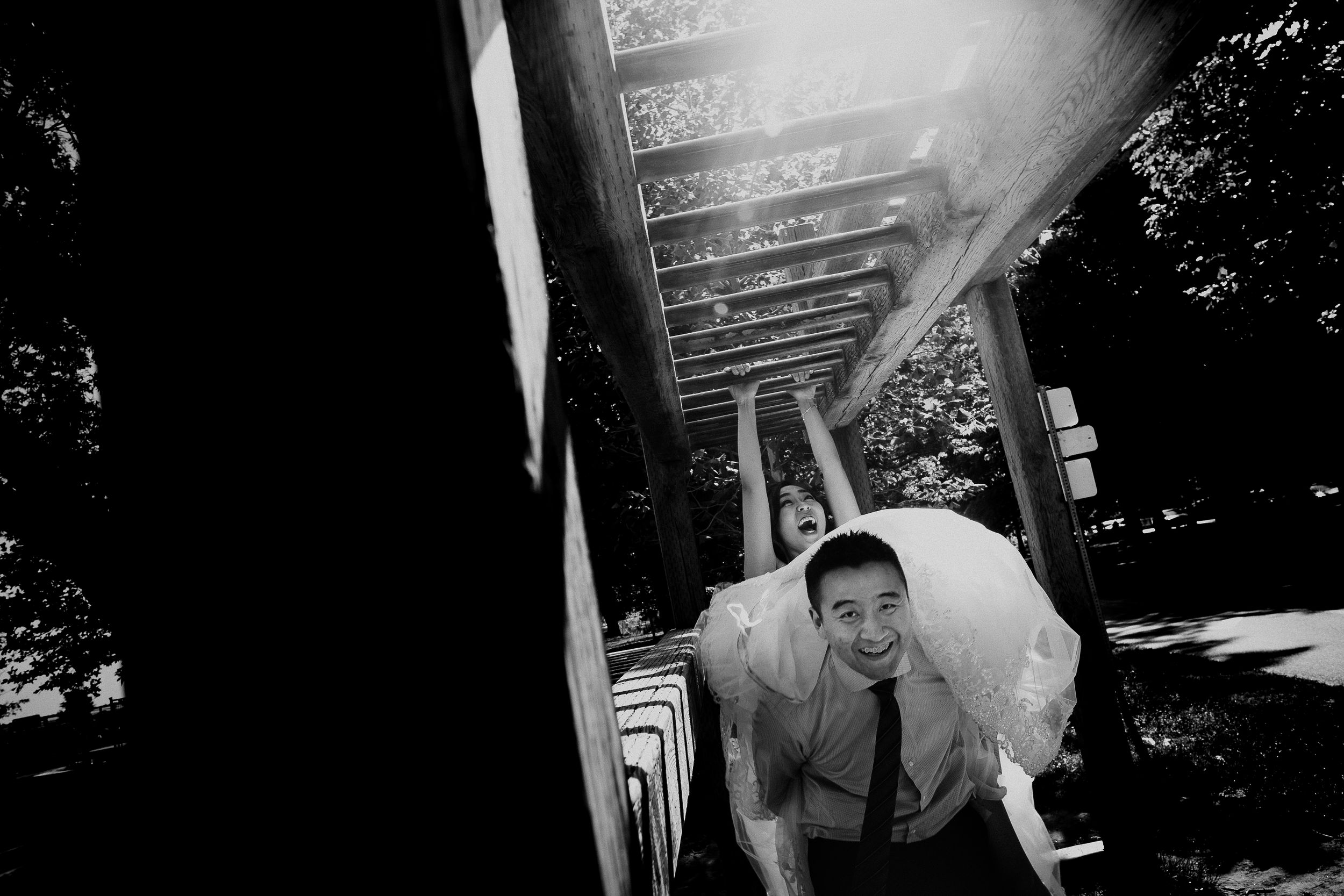 A wedding photo taken through architectural elements with dramatic lighting and shadows.