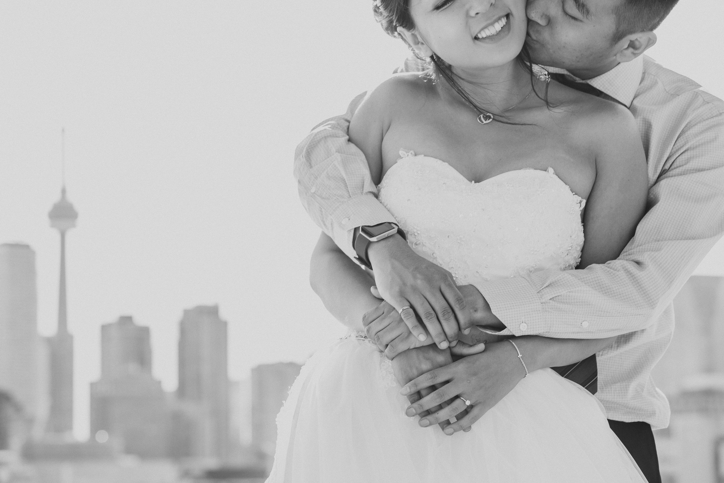 Intimate embrace with Toronto skyline visible in the background.