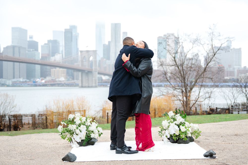 Emotional proposal moment in NYC with floral design and rainy skies