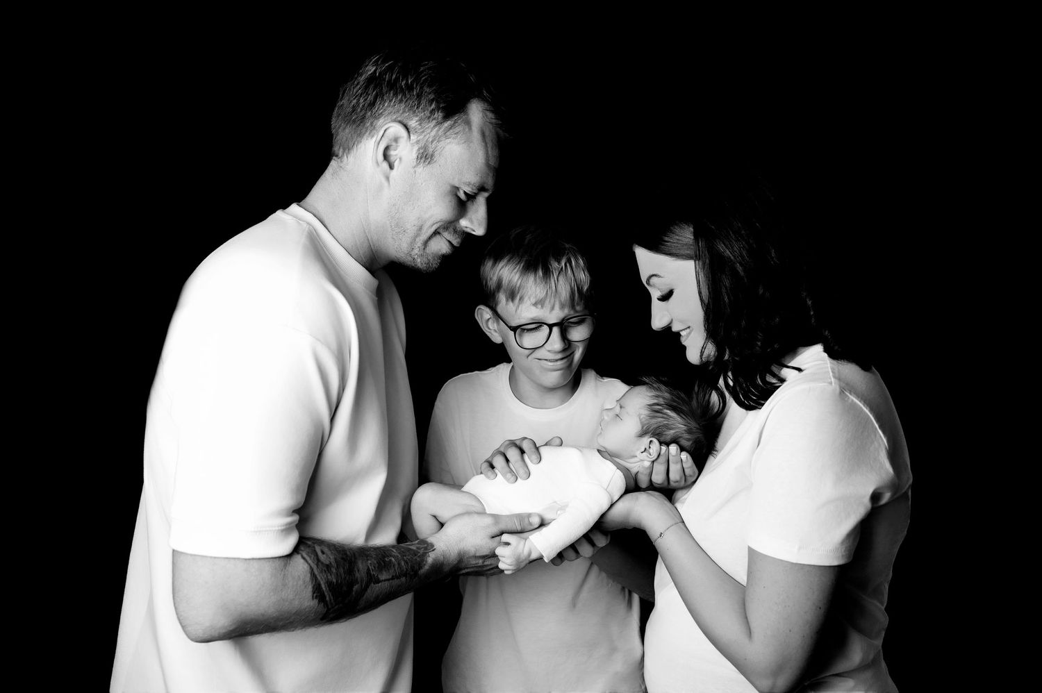 Black and white image of family gathered together sharing intimate moment.