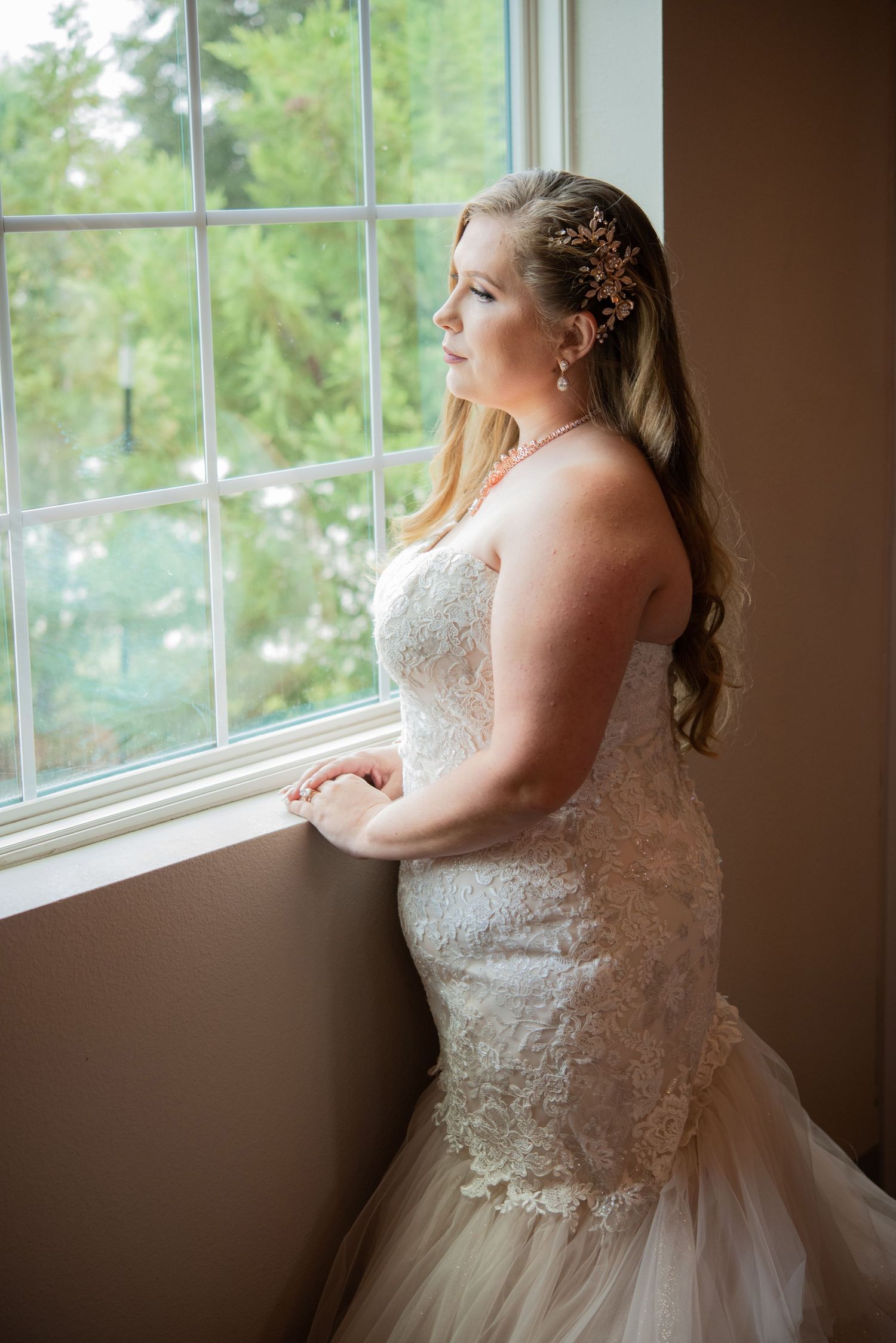 A bride in a white lace wedding dress gazes thoughtfully out of a sunlit window in a sequence of soft, romantic photos.