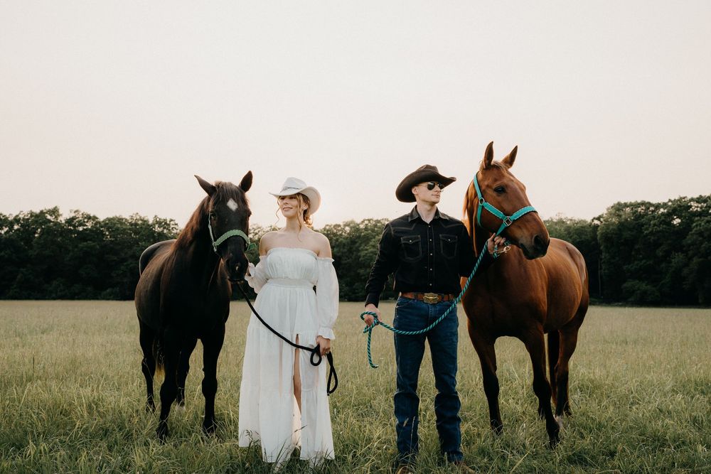 Couple standing with horses on a farm in NJ for an engagement photoshoot