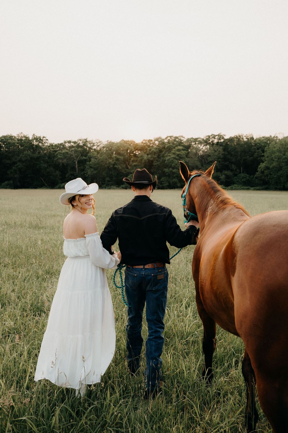 Couple standing with horses on a farm in NJ for an engagement photoshoot