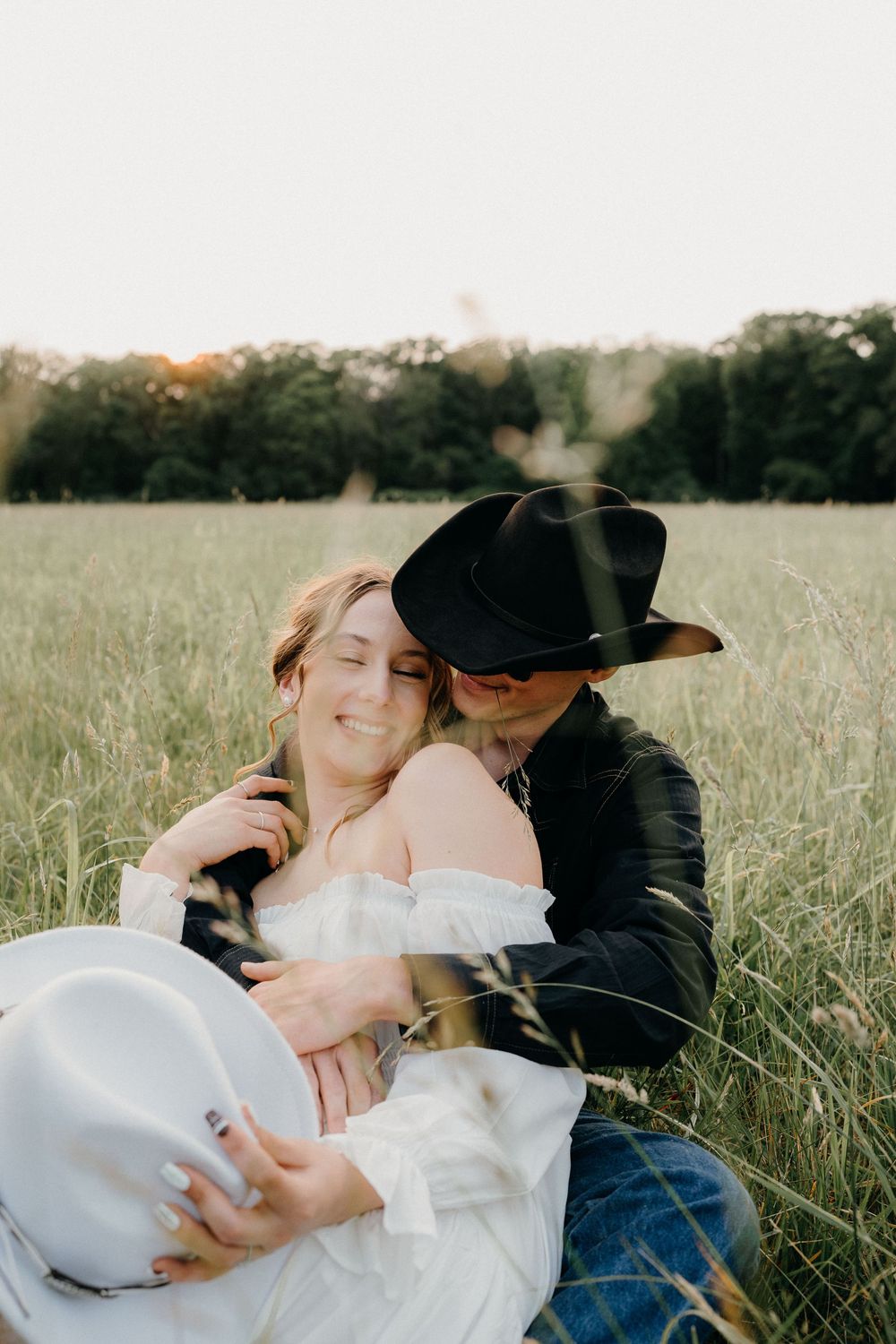 Couple posing on a farm in NJ for an engagement photoshoot wearing cowboy hats