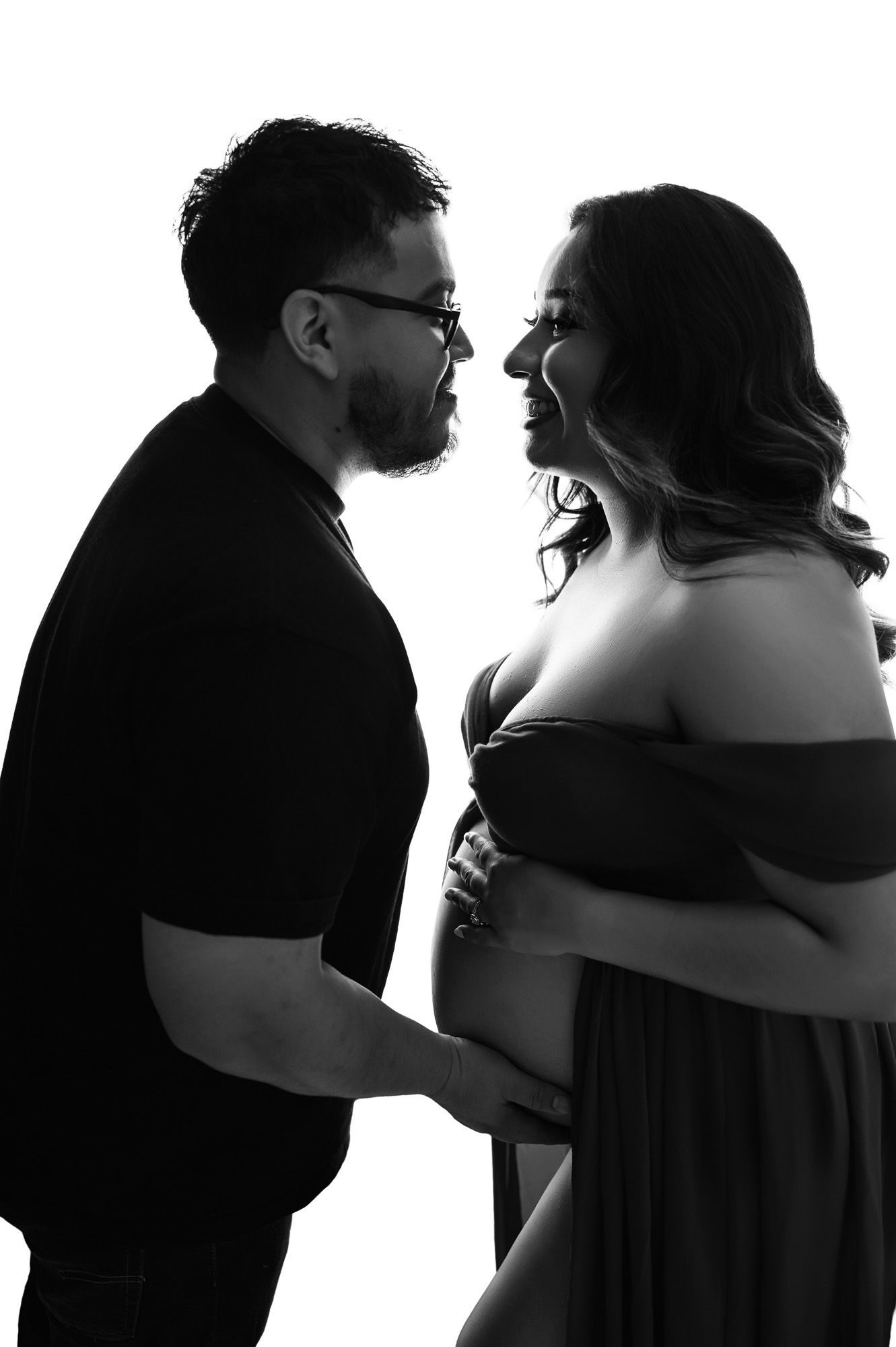 Black and white silhouette of expecting couple in studio, captured by Fresno maternity photographer to honor sacred connection.