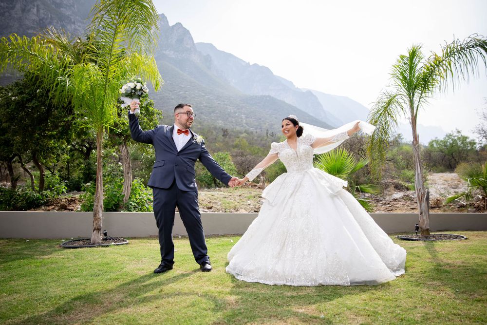 A joyful celebration on a lawn with dramatic mountain peaks in the background.