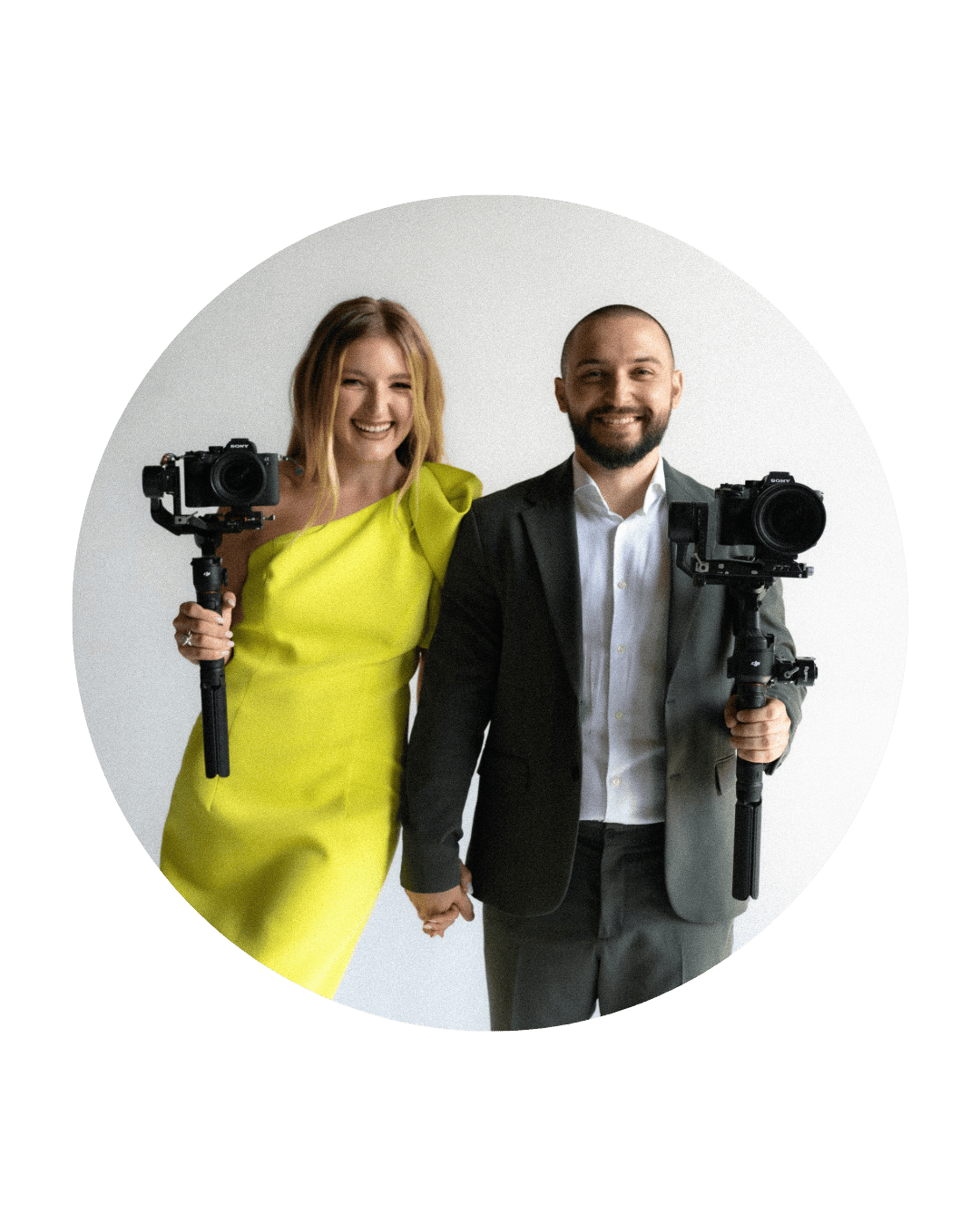 Professional videographers with camera gimbals pose together against white backdrop wearing yellow dress and suit.