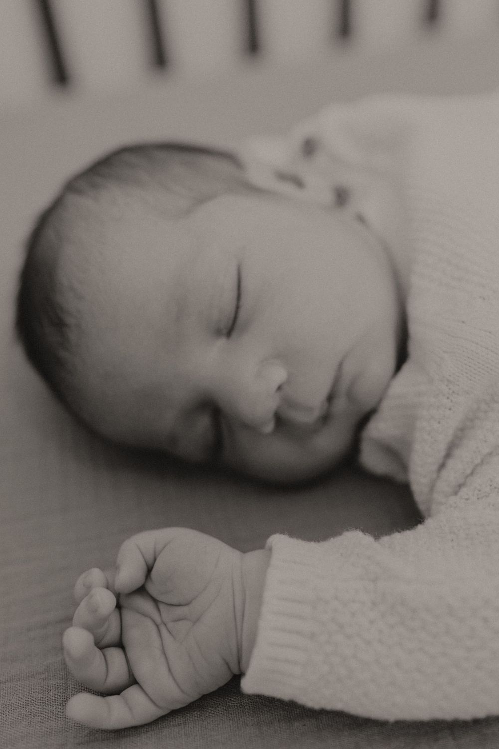 A peaceful sleeping newborn baby in soft white clothing.