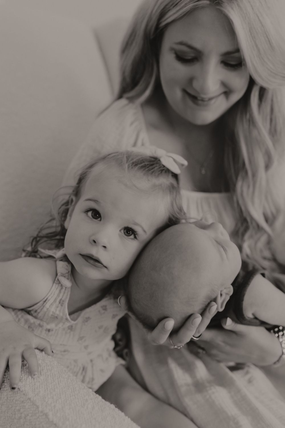 A black and white portrait capturing a tender maternal moment.