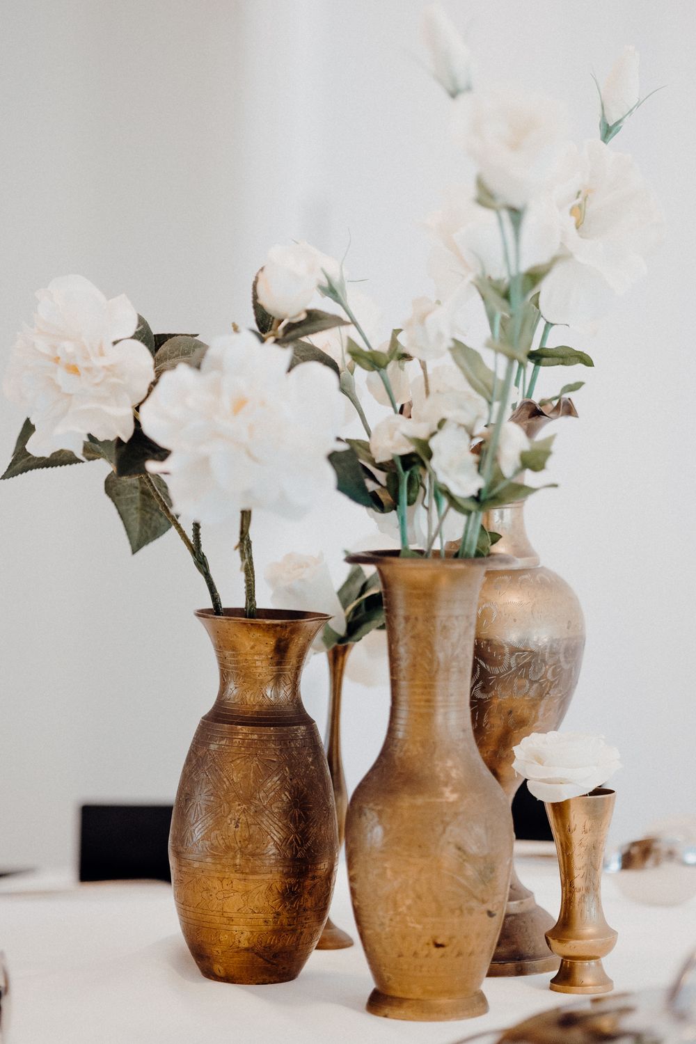 Rustic brown ceramic vases filled with delicate white roses captured by Apertured Media Auckland Wedding Photographer