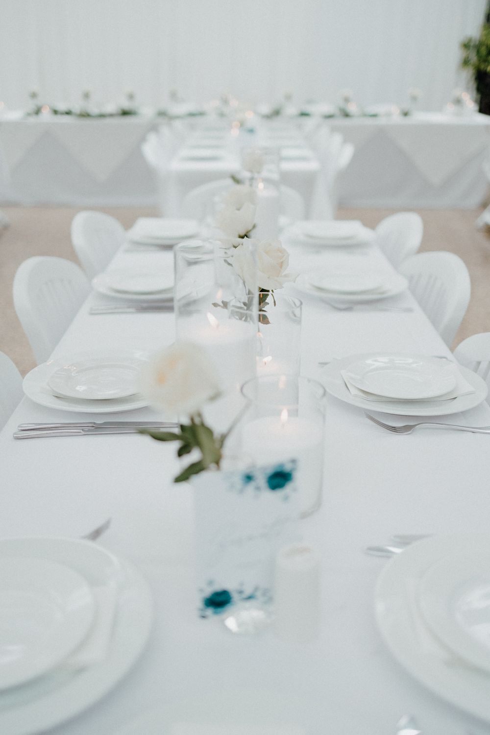 An elegant white wedding table setting with crisp linens captured by Apertured Media Auckland Wedding Photographer.