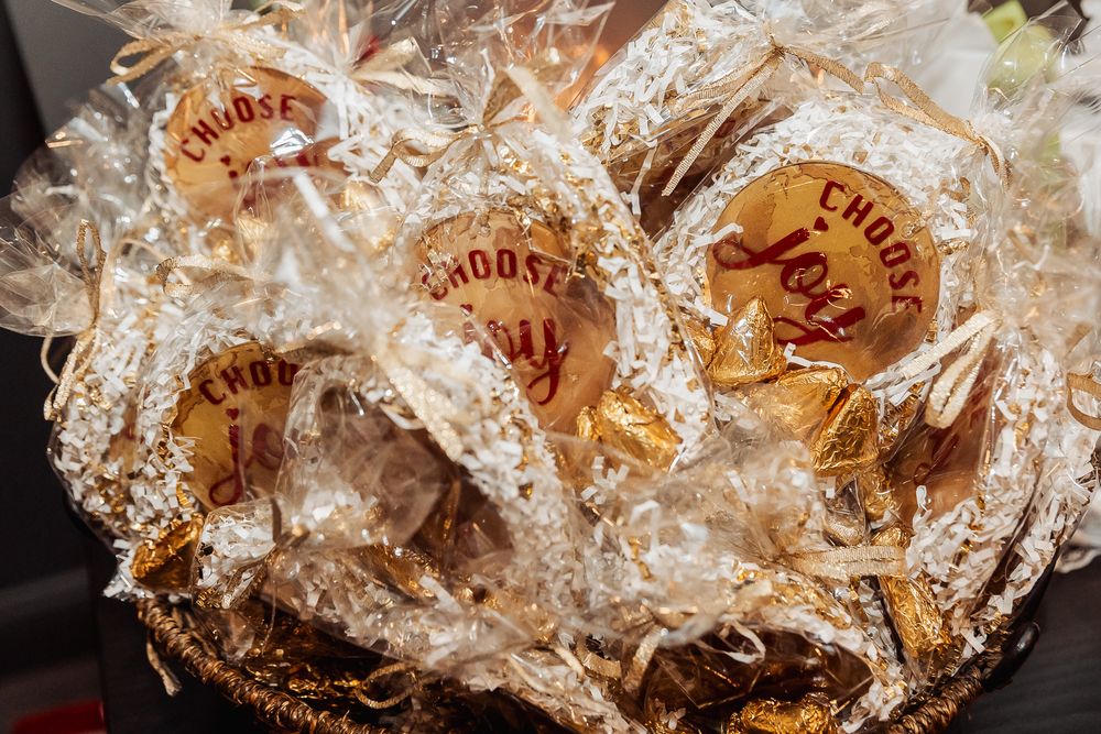 Decorative party favors wrapped in white tissue paper with red branded labels.