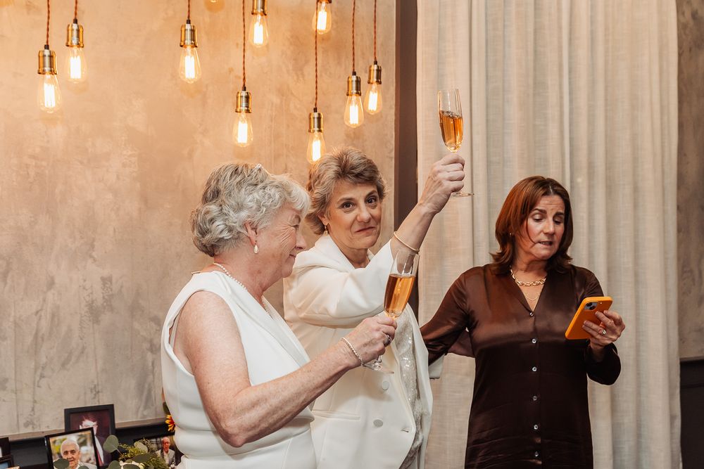 Guests raising glasses in celebration under stylish pendant lighting.