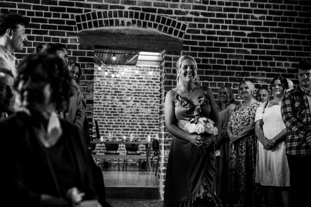 A wedding celebration in an industrial brick venue with guests gathered for a ceremony.