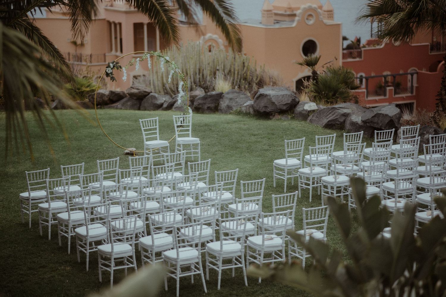 Garden wedding venue with rows of white chairs arranged for an outdoor ceremony.