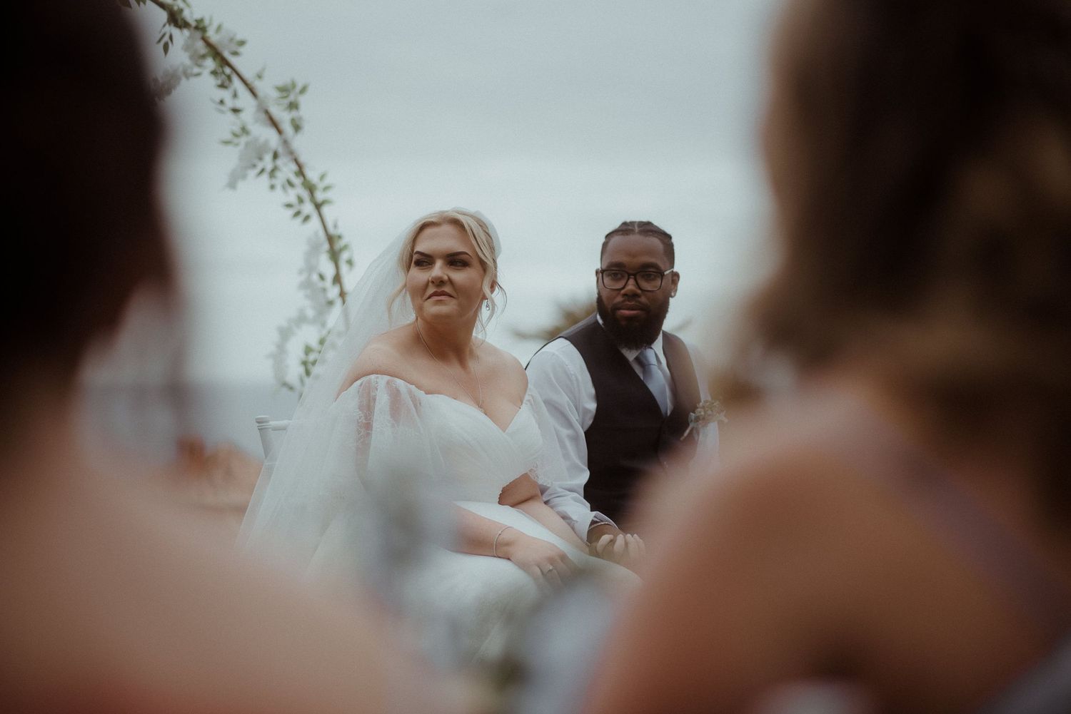 Intimate wedding ceremony moment captured through guests with ocean backdrop. Tenerife Wedding Photographer at Hotel Vincci La Plantación