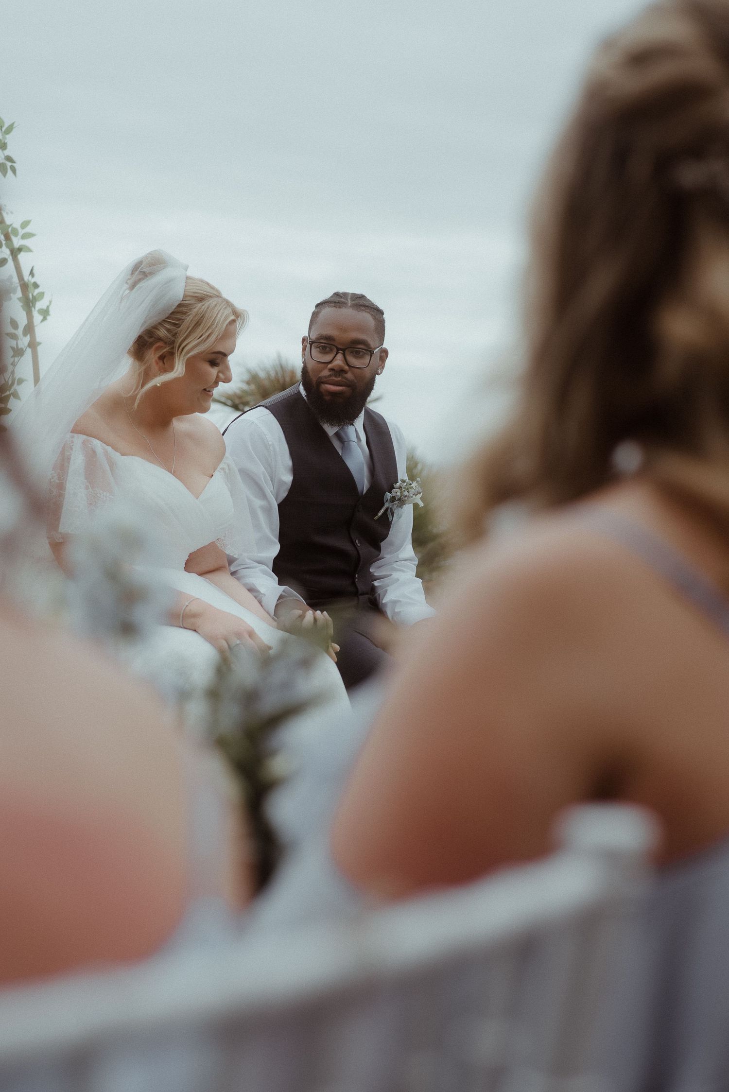 Wedding ceremony captured through guests with decorative arch and ocean views. Tenerife Wedding Photographer at Hotel Vincci La Plantación d