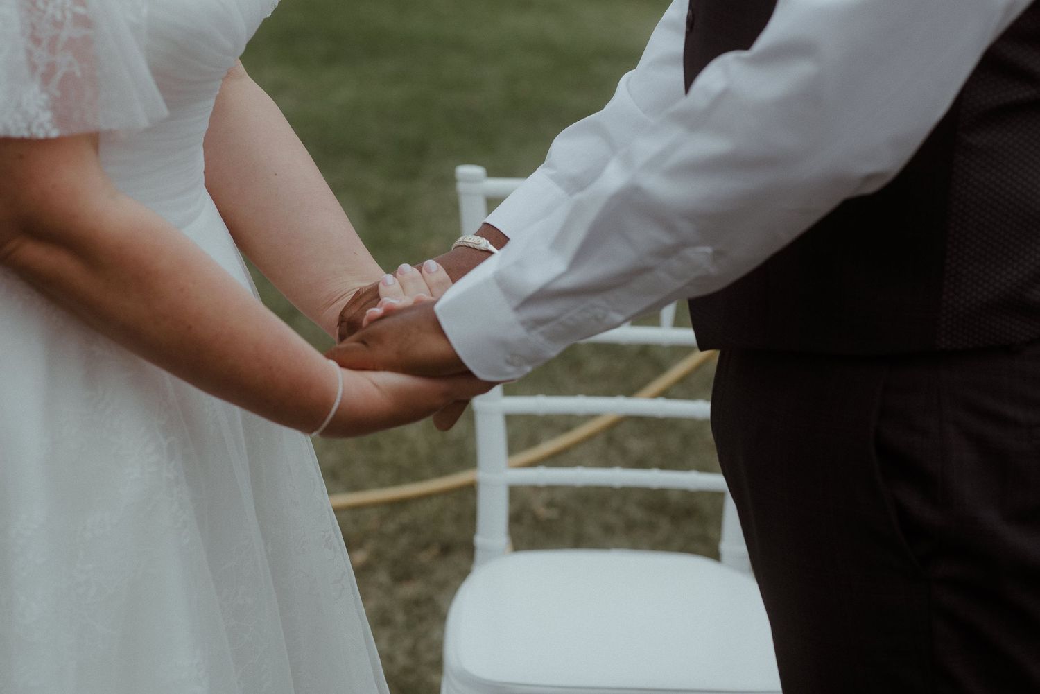 Close-up of joined hands during an intimate outdoor wedding ceremony moment. Tenerife Wedding Photographer at Hotel Vincci La Plantación