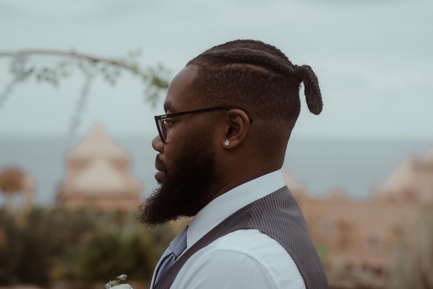 Side profile portrait against blurred coastal architecture background. Tenerife Wedding Photographer at Hotel Vincci La Plantación del Sur