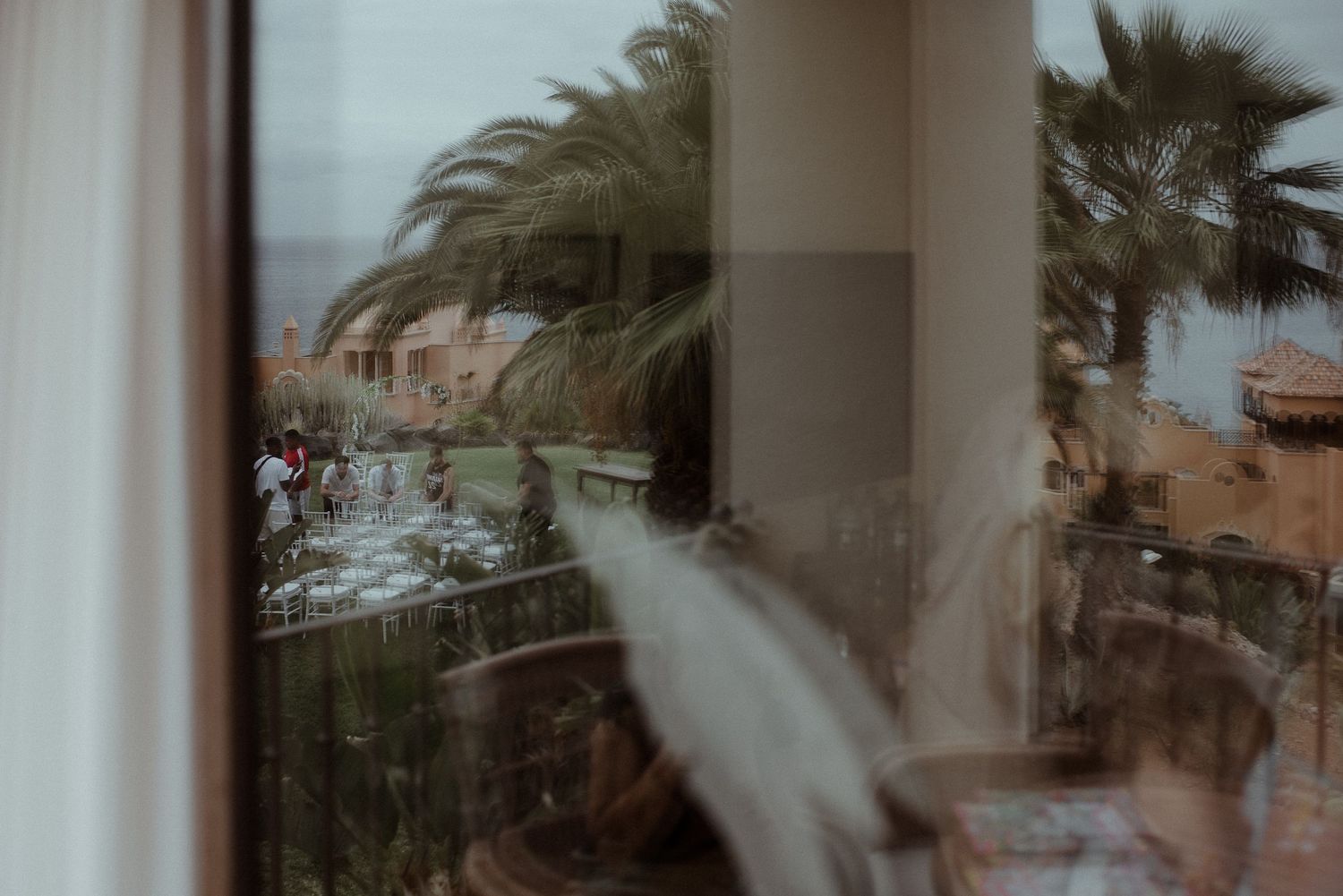 Blurred view through window of palm trees and coastal landscape.