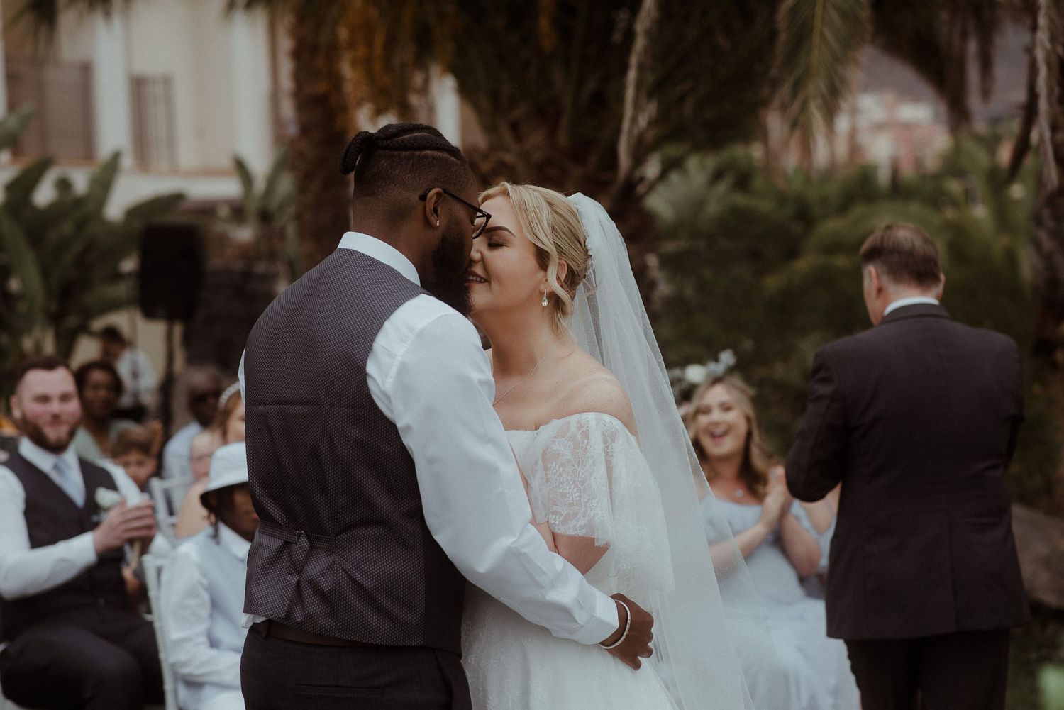 Couple sharing intimate moment during outdoor wedding celebration.