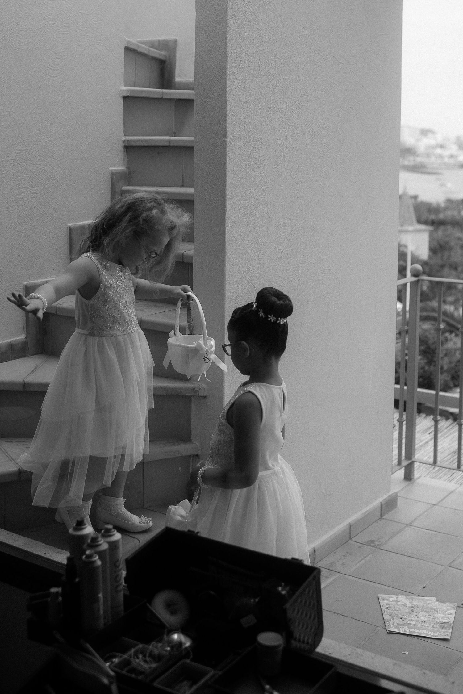 Black and white photo of children in tulle dresses on a balcony.