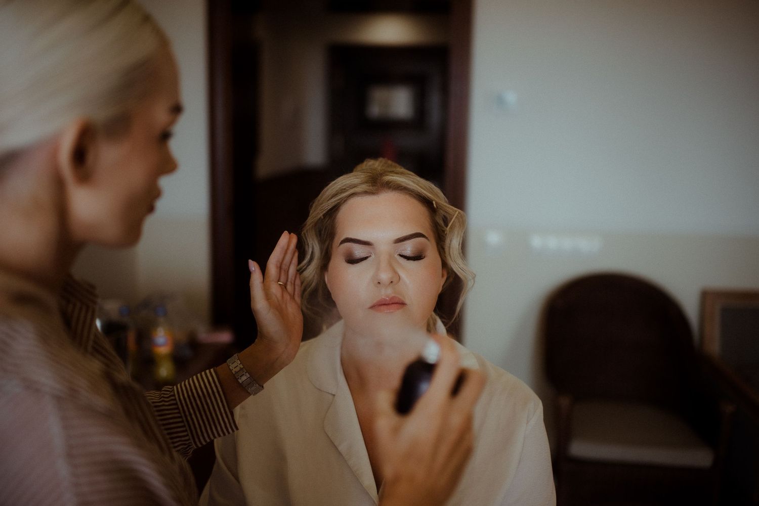 Professional makeup application being done in a warmly lit room. Tenerife Wedding Photographer at Hotel Vincci La Plantación del Sur