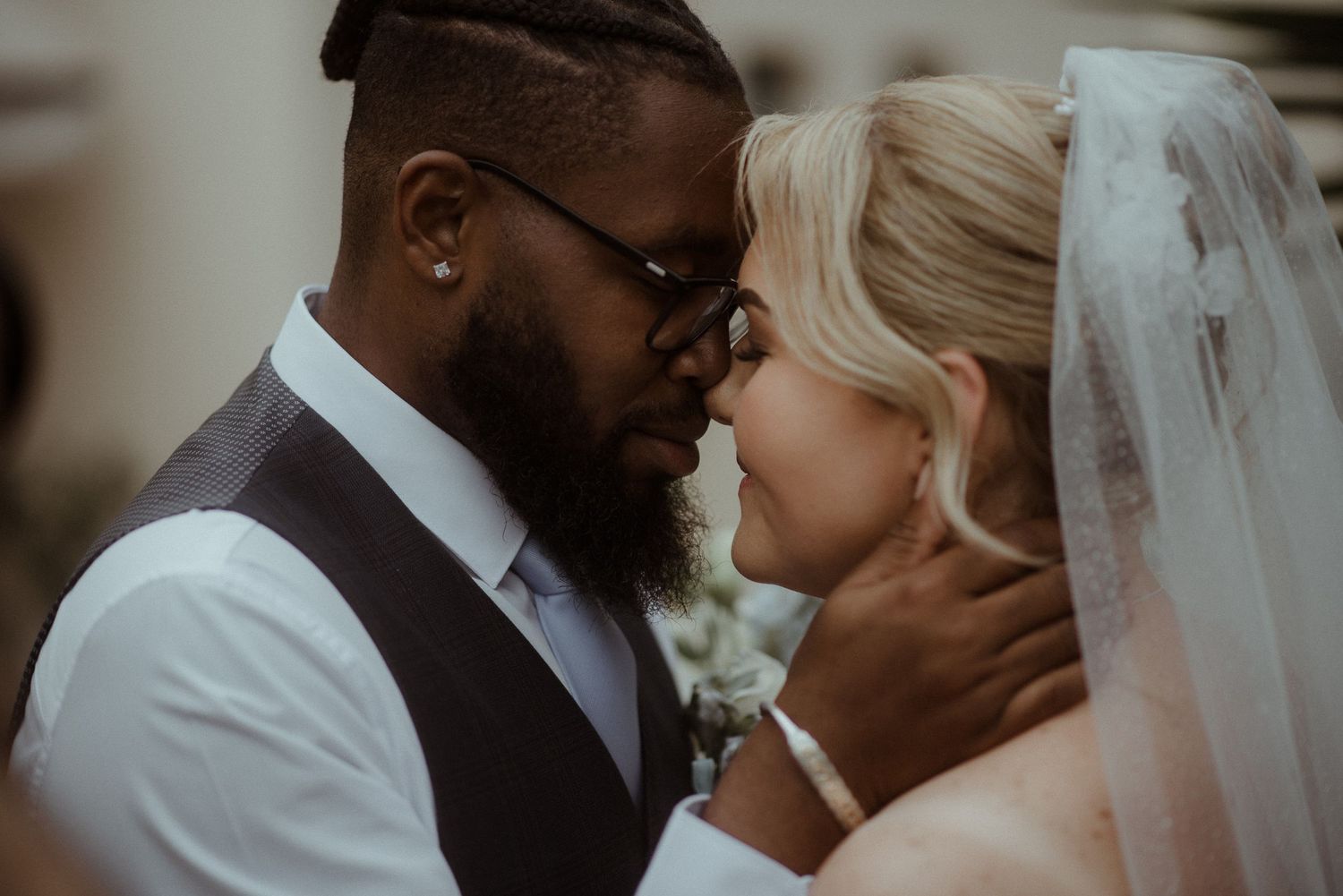 Tender wedding moment captured in warm tones as couple shares intimate embrace.