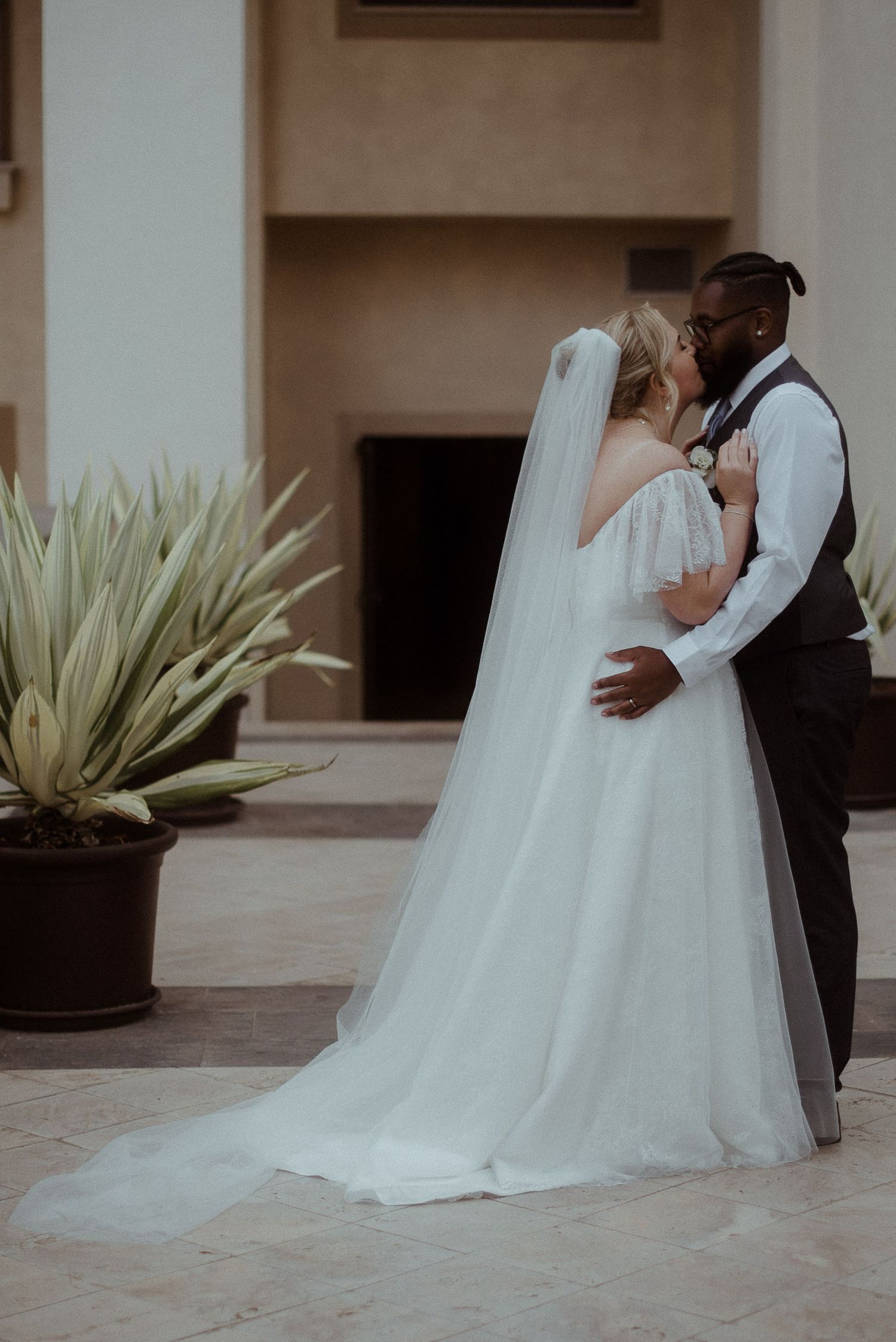 Full length wedding portrait with flowing white dress and desert landscaping.