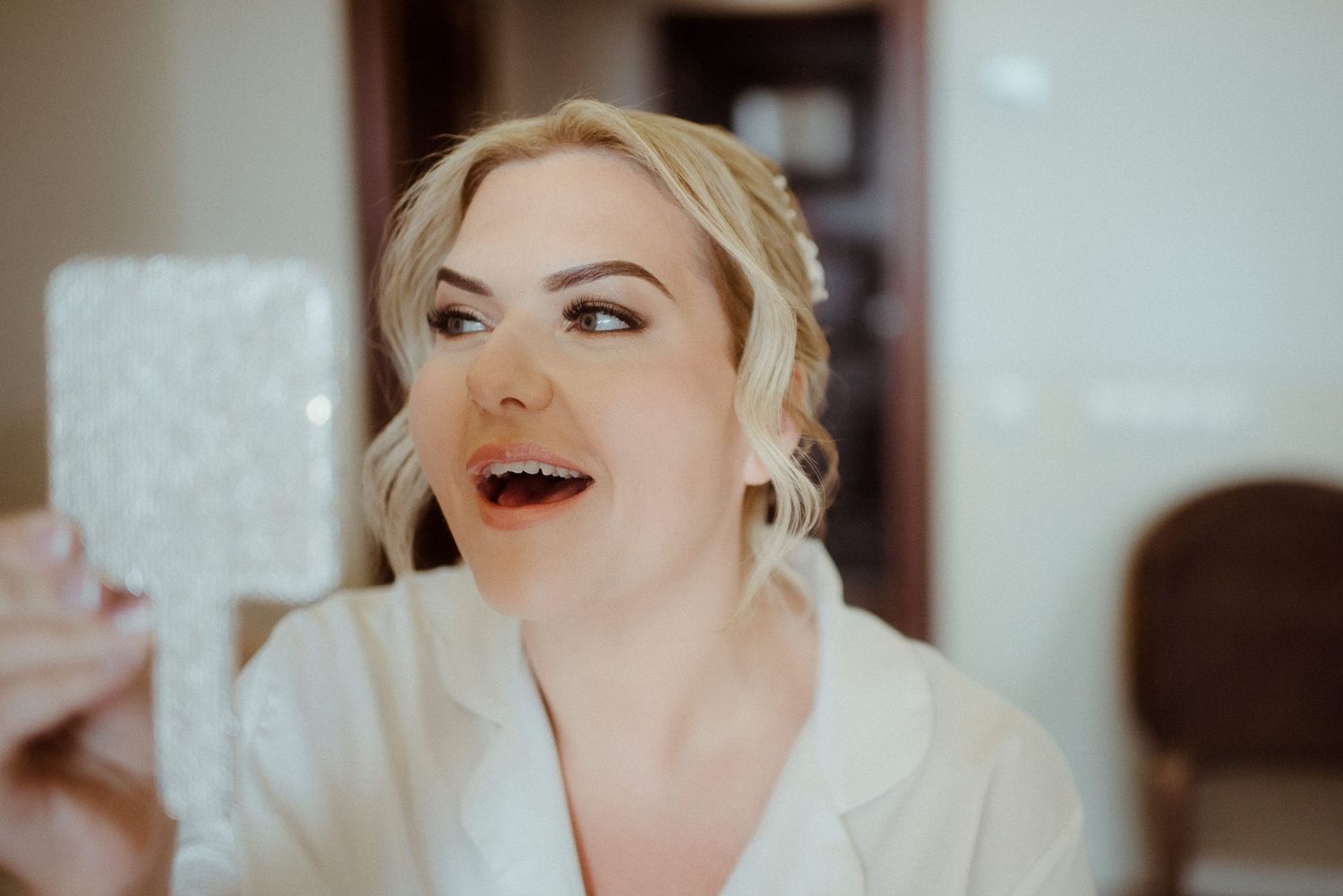 Candid moment during bridal preparation showing genuine joy and laughter.