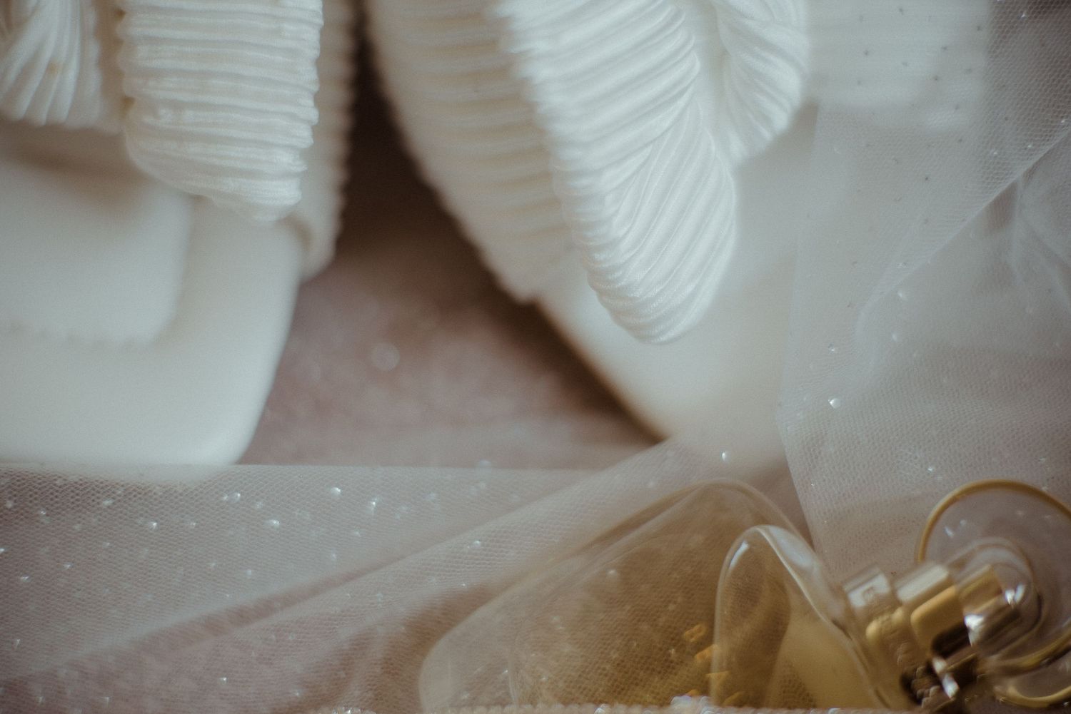 Dreamy macro shot of wedding rings through layers of white tulle fabric. Tenerife Wedding Photographer at Hotel Vincci La Plantación del Sur