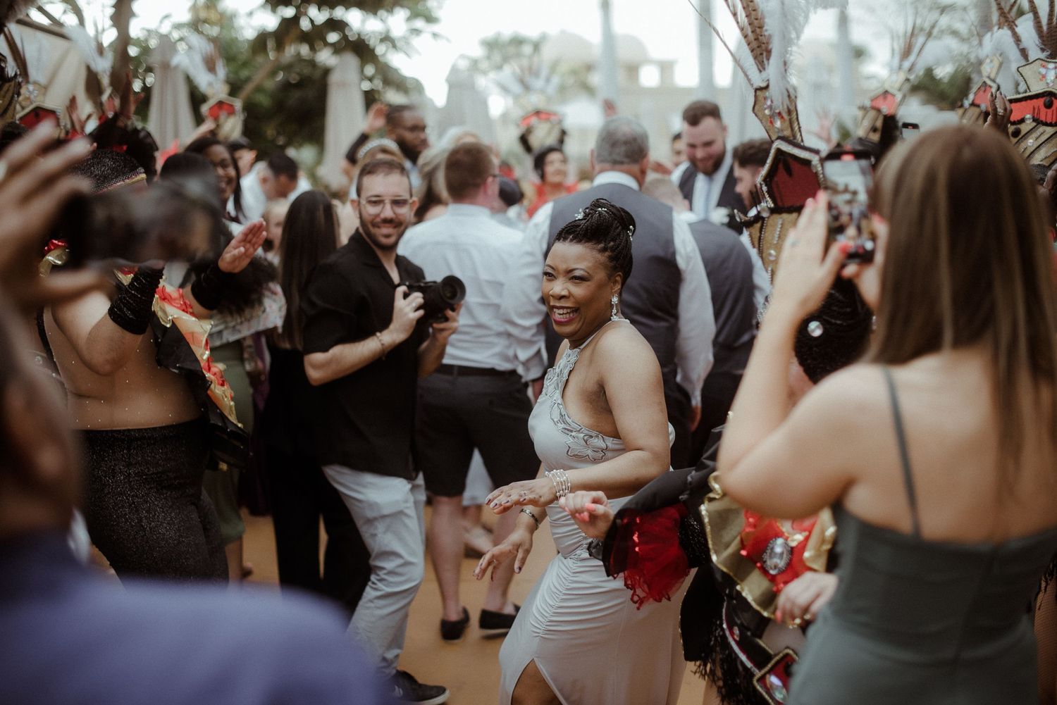 Wedding guests dance and celebrate on a crowded dance floor at an evening reception.