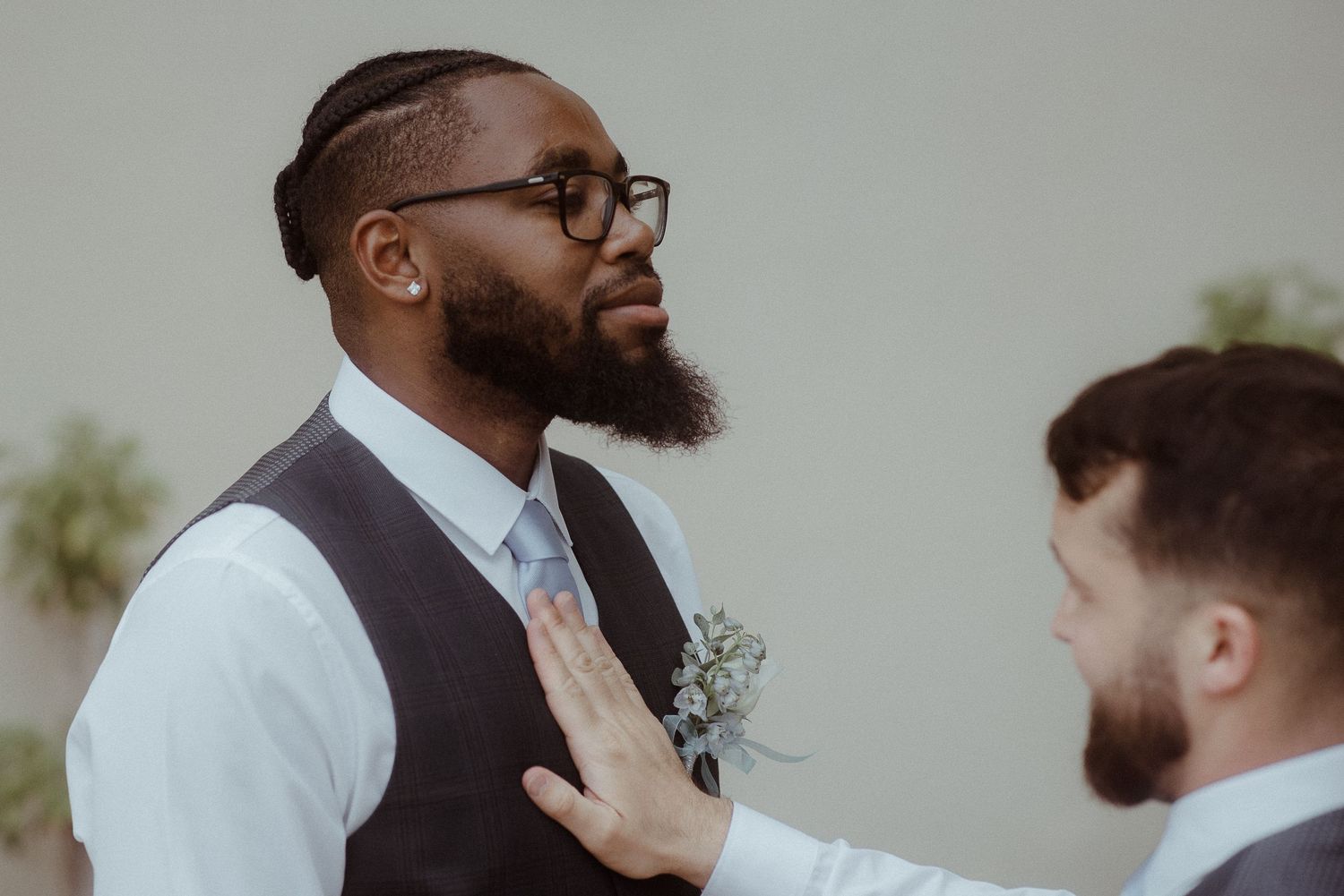 Groomsmen in matching vests helping with wedding day preparations.