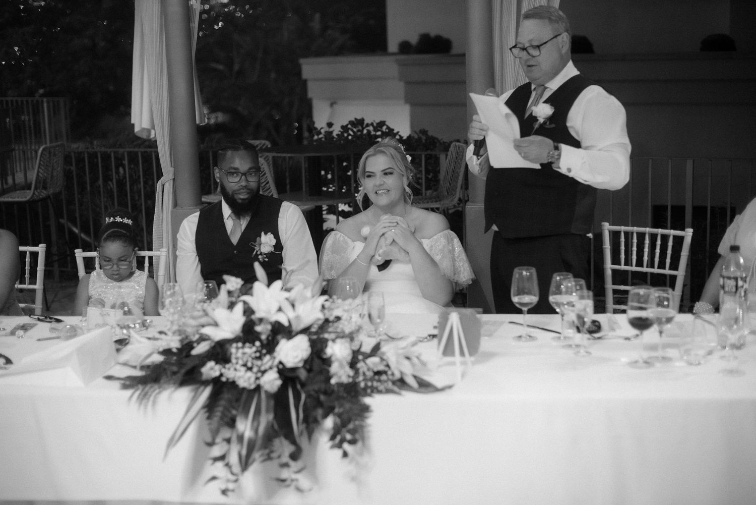 Classic black and white photo of wedding speeches at the reception head table.