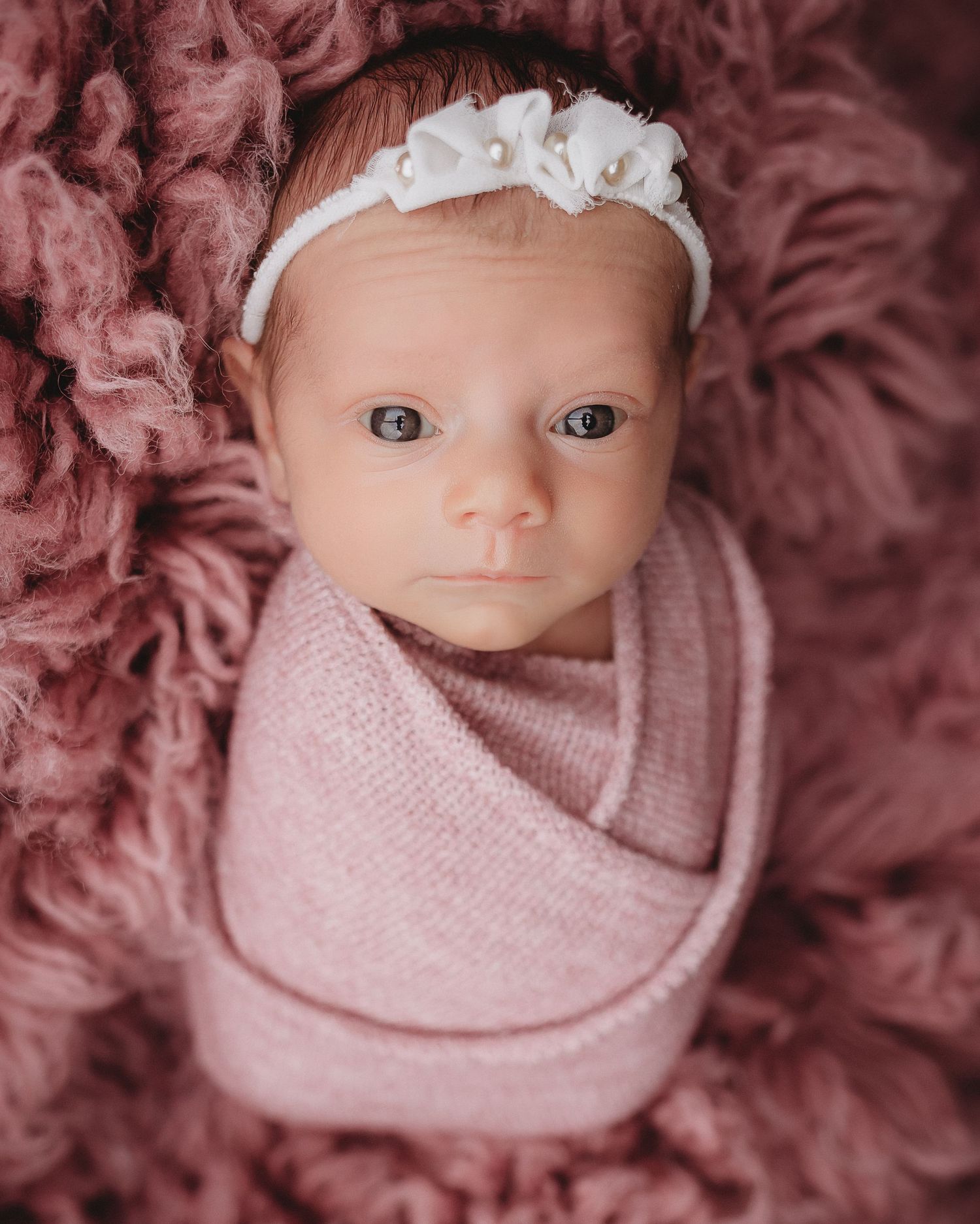 Professional photo of a newborn baby awake and looking at the camera