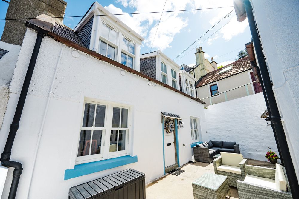 White coastal buildings with steep steps and narrow passageways under bright blue skies.