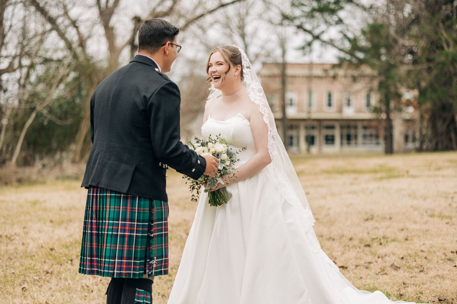 Outdoor wedding ceremony with Scottish tartan kilt details and elegant white bridal gown against natural backdrop.