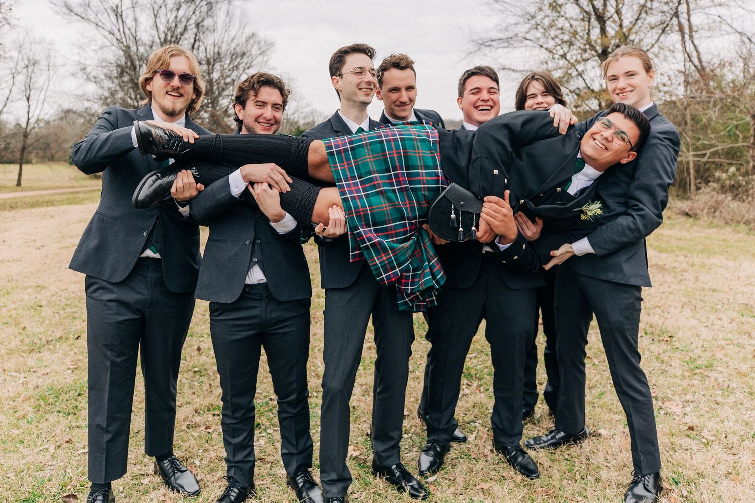 Groomsmen in black suits having fun posing outdoors in a series of candid group photos.