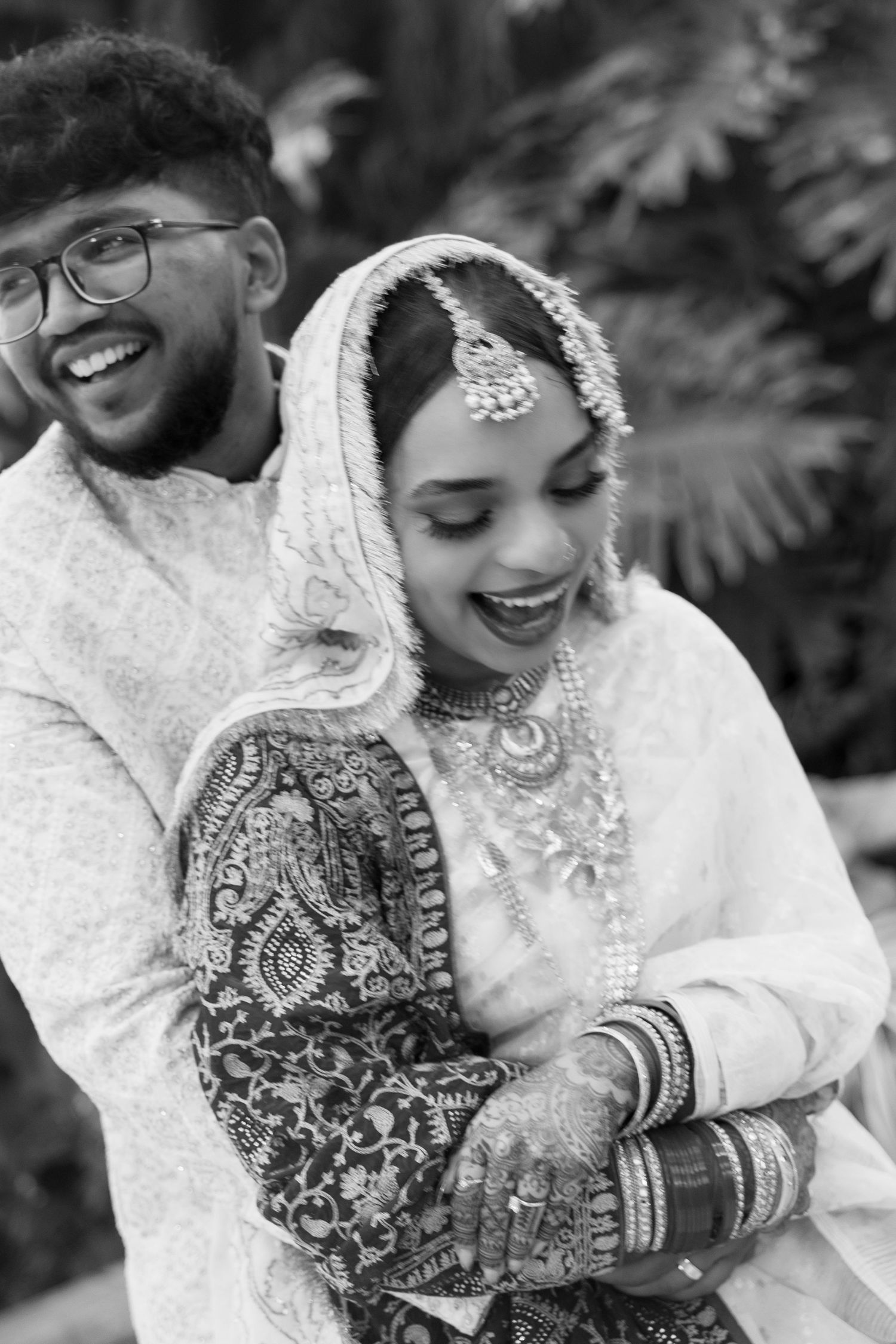 A joyful moment captured in black and white at a traditional South Asian wedding ceremony.